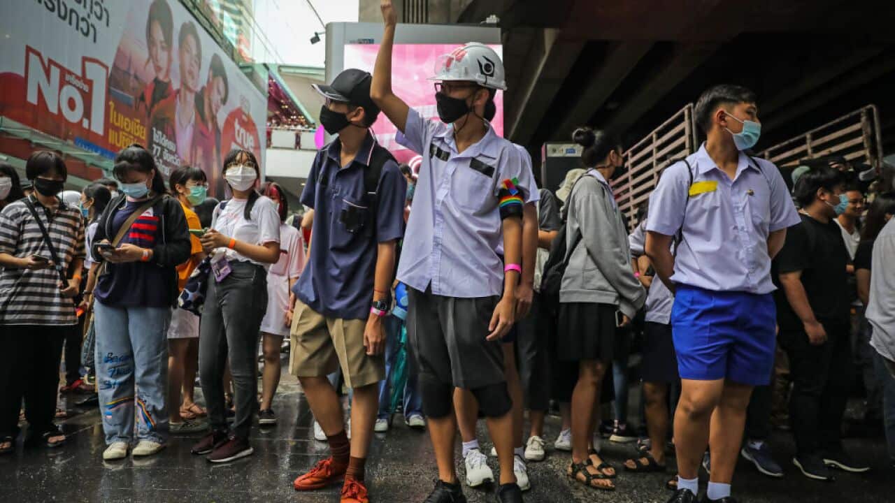 Protesters flash three finger salutes in the Siam area on 21 November, 2020 in Bangkok, Thailand.