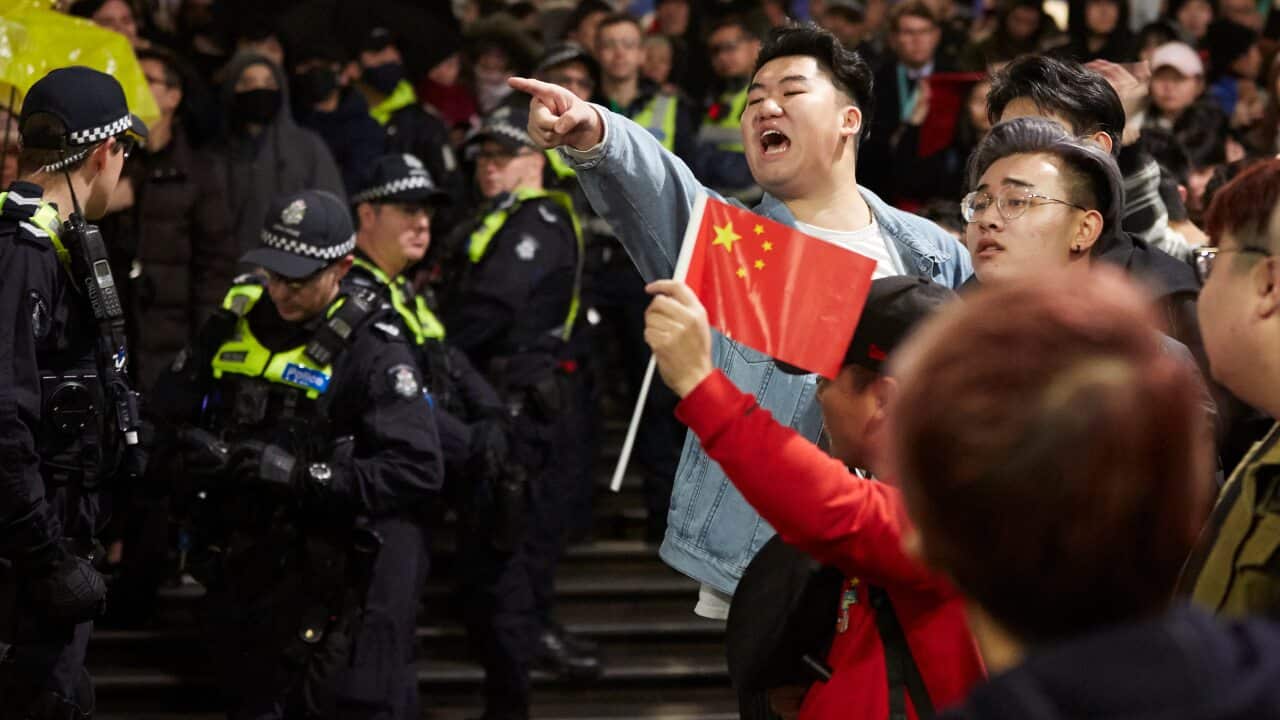 Pro-China counter protesters gesture towards Hong Kong democracy demonstrators during a rally at the State Library in Melbourne.