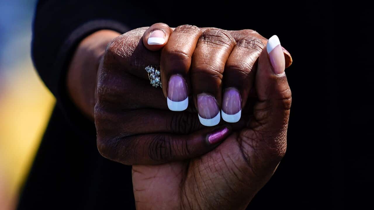 People hold hands as they pray outside the scene of a shooting at a supermarket in Buffalo, N.Y., Sunday, May 15, 2022. (AP Photo/Matt Rourke)