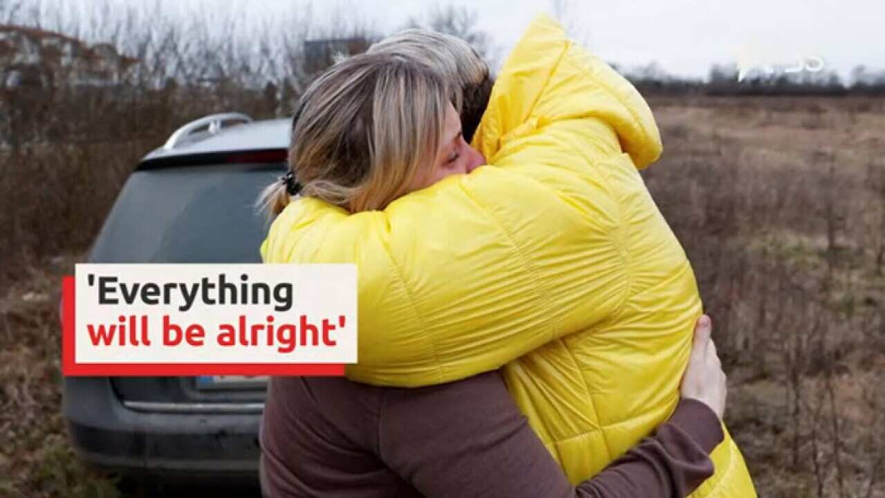 Ukranian mother hugs her children brought to safety by a stranger