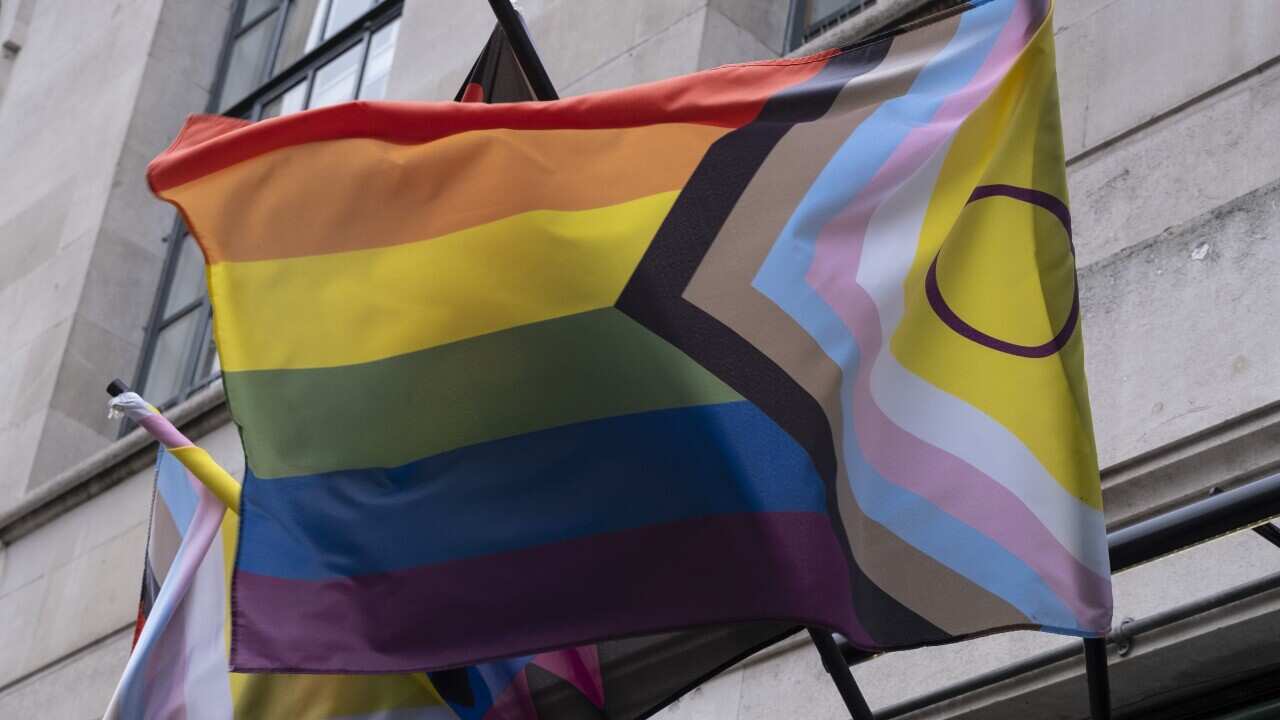Intersex Progress Pride Flag waving in wind outside a building