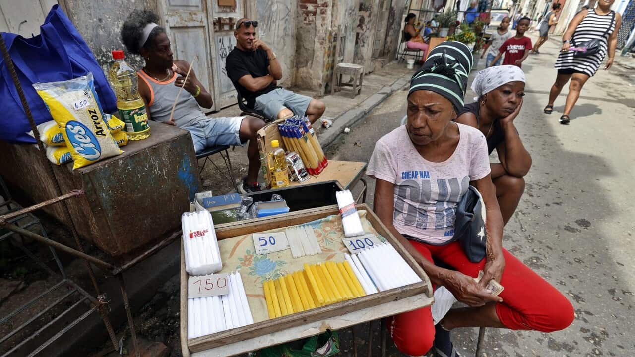 A woman sells candles during a power outage in Havana, Cuba (AAP)