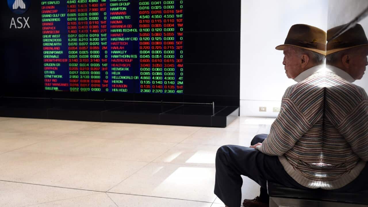 A man looks at stock prices at the Australian Securities Exchange