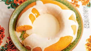 Ring-shaped sformati di carote (carrot flans) with parmesan cream, on a green patterned plate