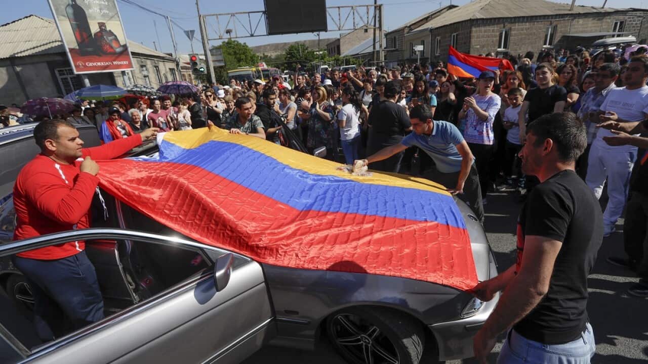 Supporters of the opposition lawmaker Nikol Pashinian hold an Armenian national flag as they block a road to the airport just outside Yerevan.