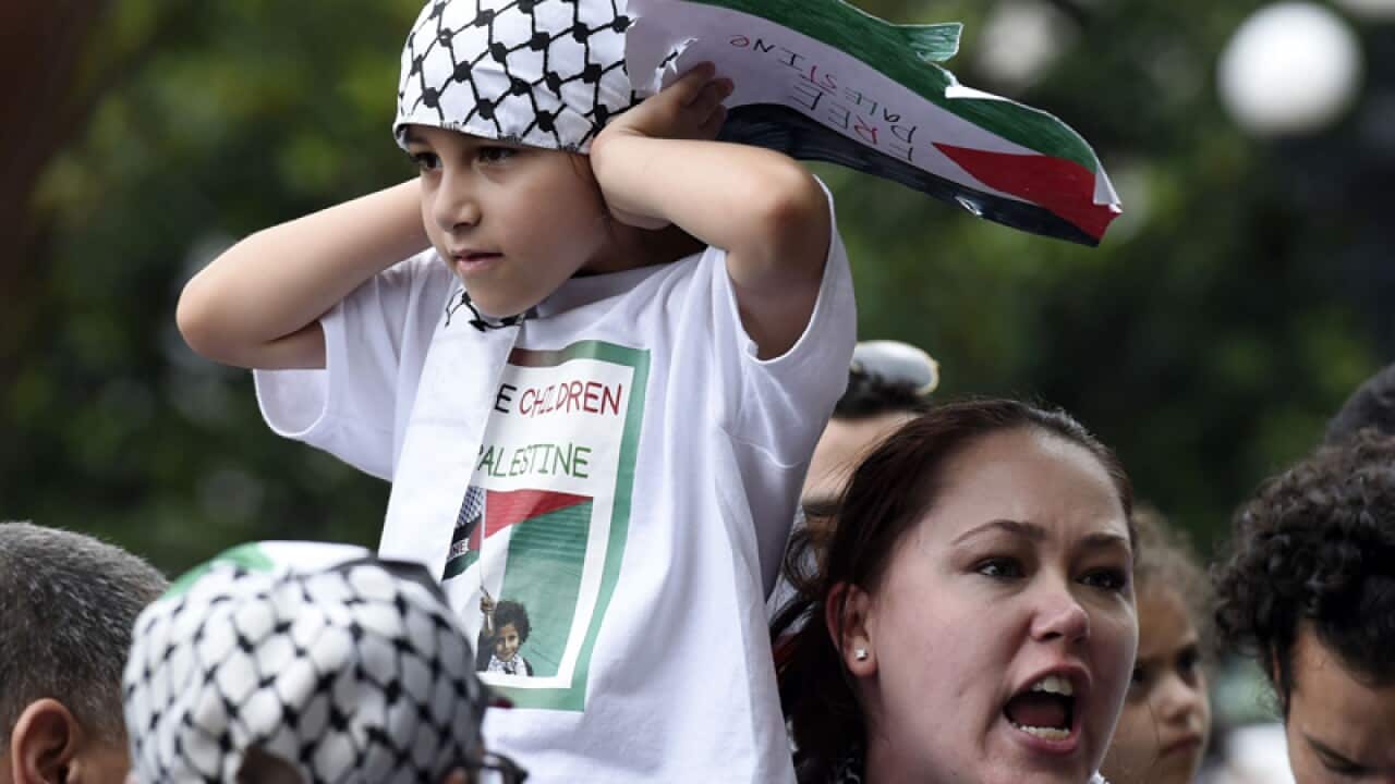 A girl covers her ears as her mother argues with pro-Israel people