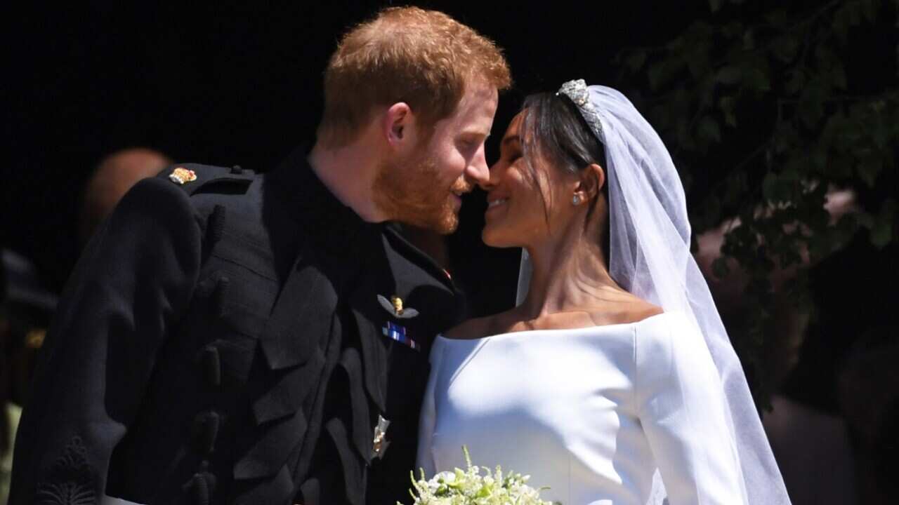 Britain's Prince Harry (L), Duke of Sussex and Meghan (R), Duchess of Sussex exit St George's Chapel in Windsor Castle