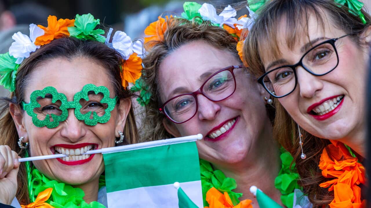 Three women with Irish tricolour headbands and glasses