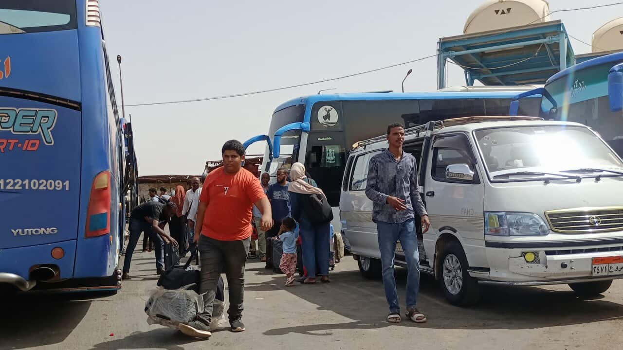 Passengers fleeing war-torn Sudan disembark at the Wadi Karkar bus station near the Egyptian city of Aswan