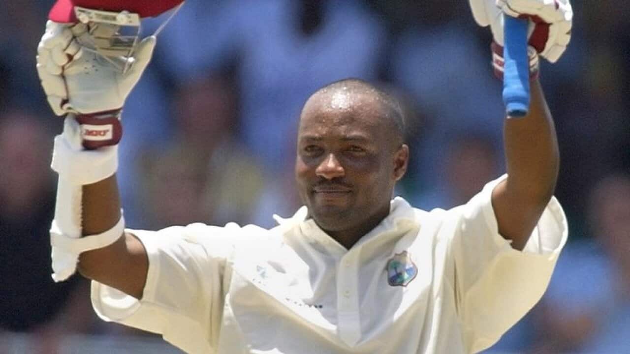 West Indies captain Brian Lara raises his bat and helmet in acknowledgement after scoring 384 runs to beat the world's highest score in test cricket.