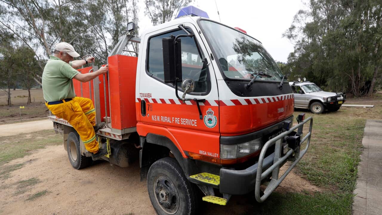 A volunteer firefighter prepares a truck as they plan their defence against a bushfire near Towamba