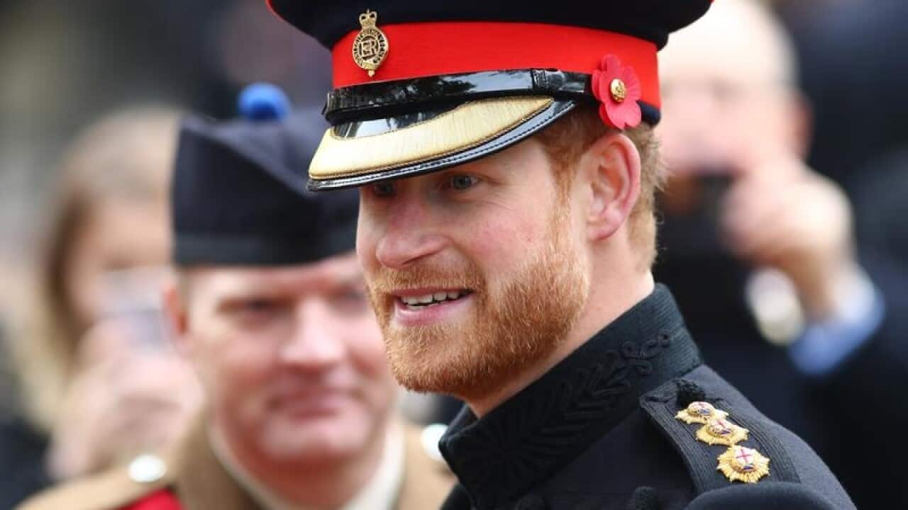 Britain's Prince Harry speaks to members of the armed forces.