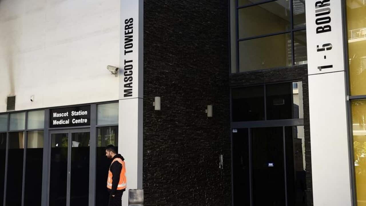 A security guard outside the entrance of Mascot Towers.