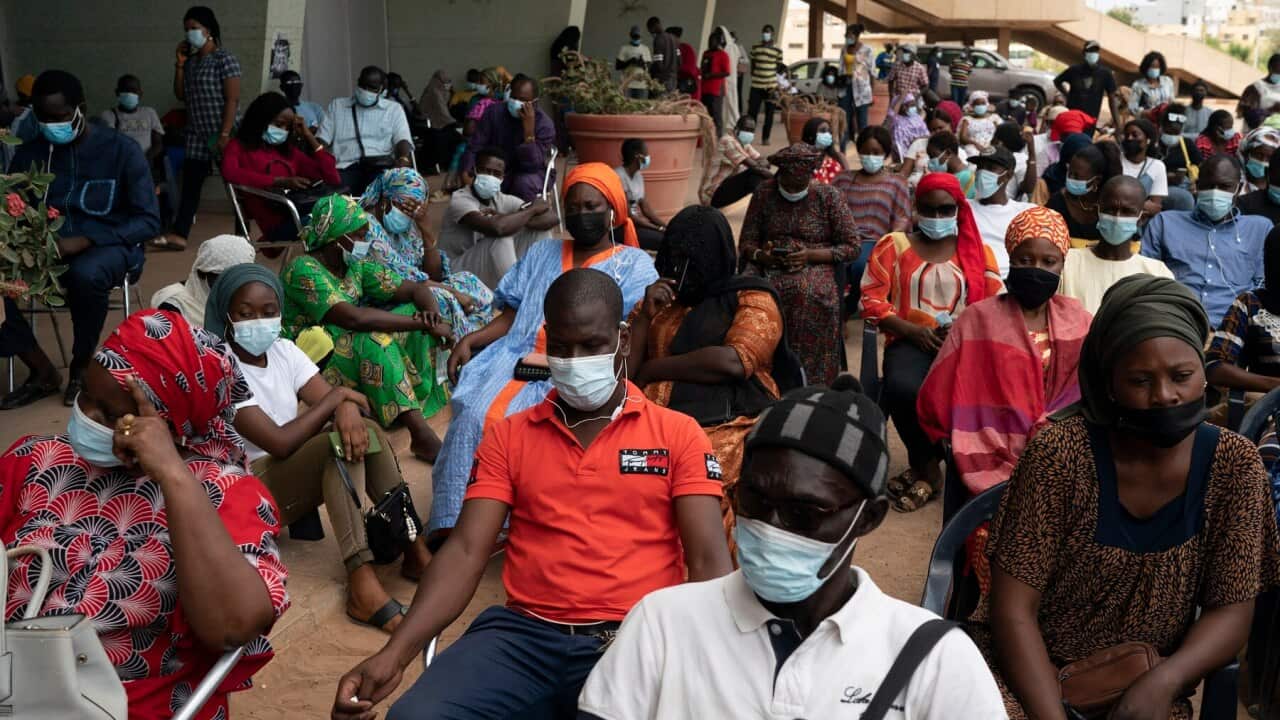 People wait to be vaccinated at Leopold Sedar Senghor stadium in Dakar, Senegal