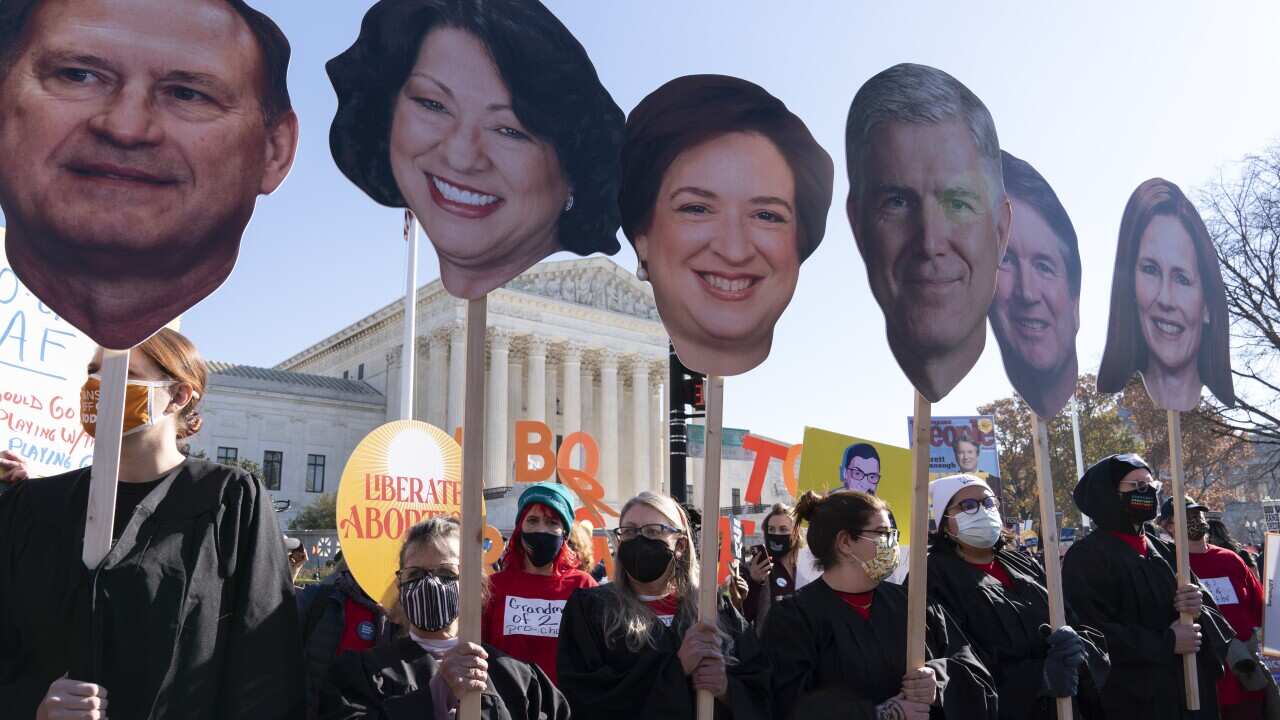 Abortion rights advocates holding cardboard cutouts of the Supreme Court Justices in front of the Court in Washington