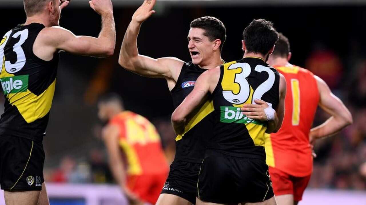 Tigers player Jason Castagna (centre) reacts after kicking a goal