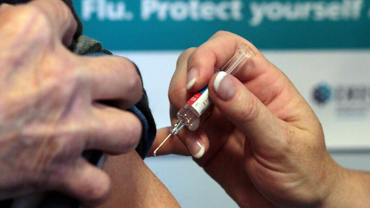 A person administers a flu vaccine.