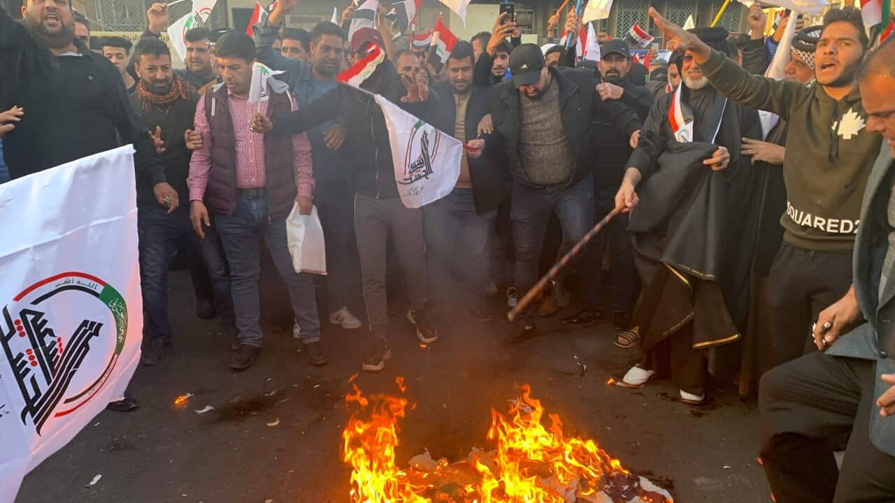 Protesters burn representations of a US flag during a protest against the US strikes on the Hezbollah Brigades militia.