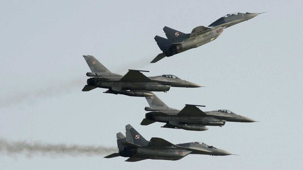 Two Polish Air Force Russian made Mig 29's fly above and below two Polish Air Force U.S. made F-16's fighter jets during the Air Show in Radom, Poland