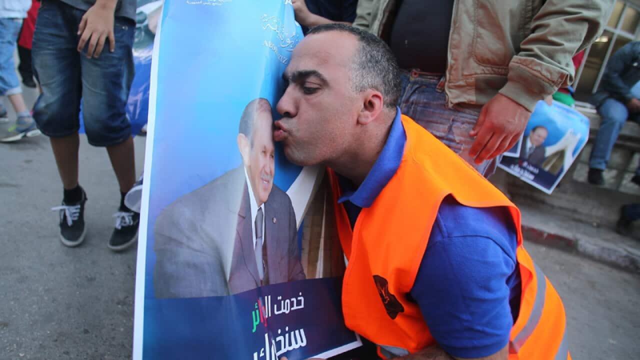 A supporter kisses Algerian President Abdelaziz Bouteflika's picture