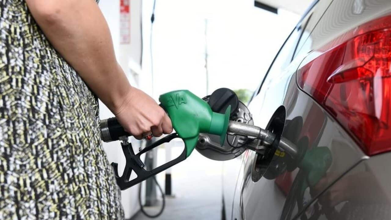 A motorist refuels her car at a service station