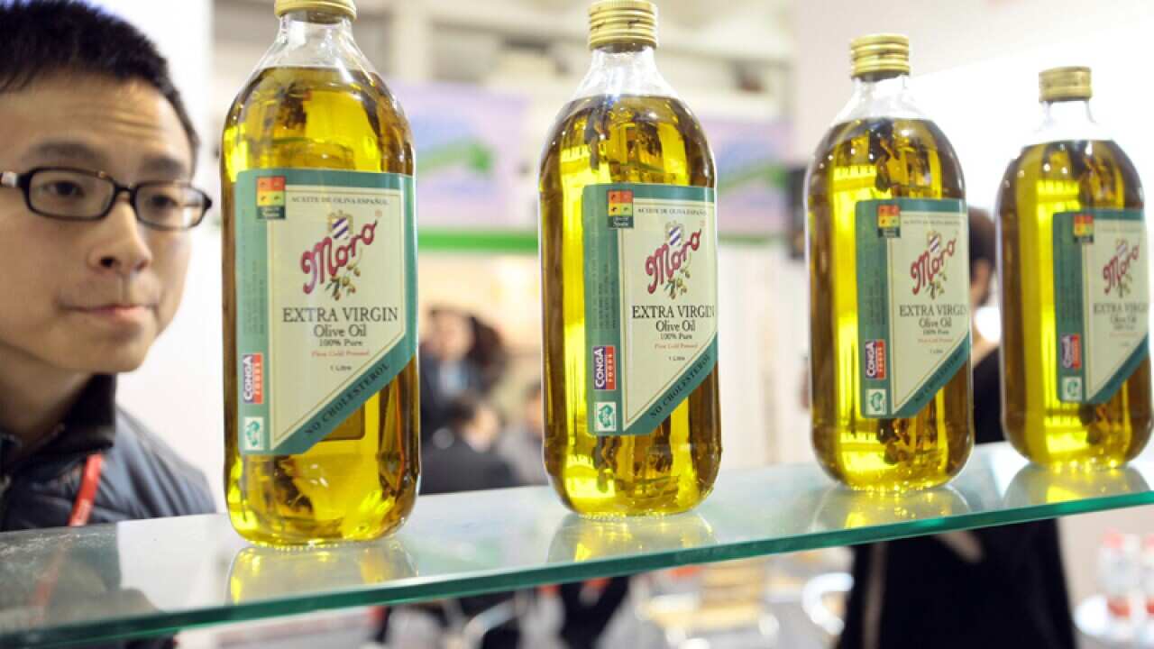 A visitor views imported olive oil at an exhibition in Shanghai China