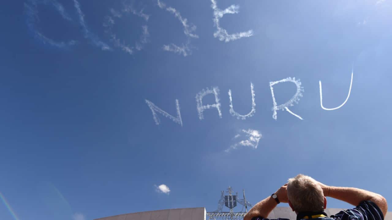 A skywriter writes Close Nauru above Parliament House