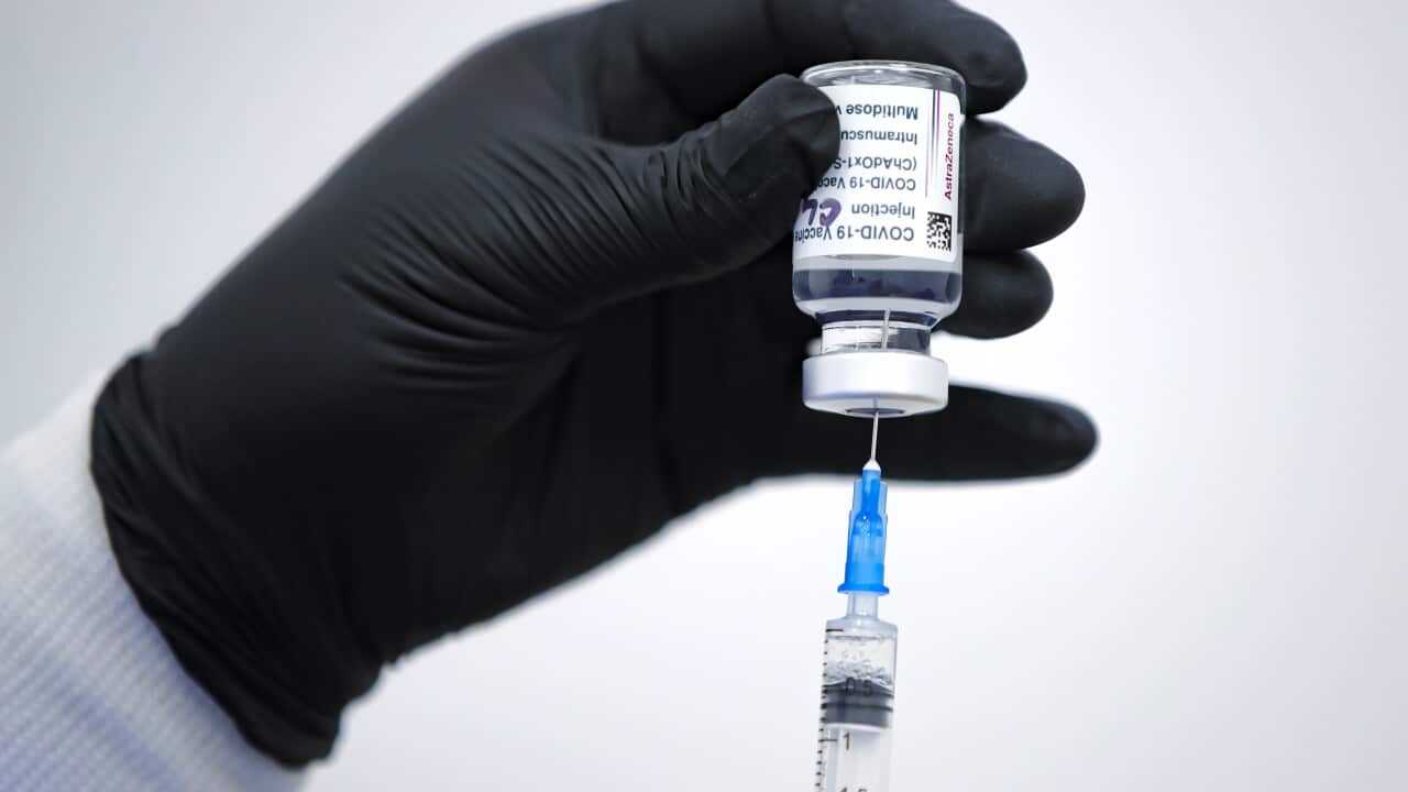 A member of the medical staff draws serum from an AstraZeneca vaccine container at a vaccination center in Bucharest, Romania, Wednesday, April 7, 2021.