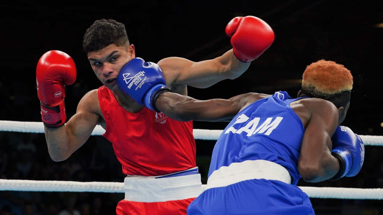 Alex winwood, in red, receives a punch in the face from his blue-clad opponent.