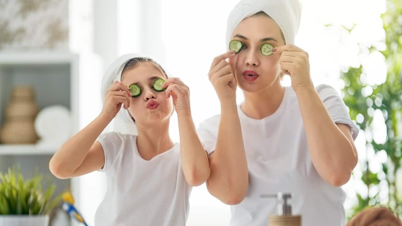 Happy family! Mother and daughter child girl are caring for skin in the bathroom.