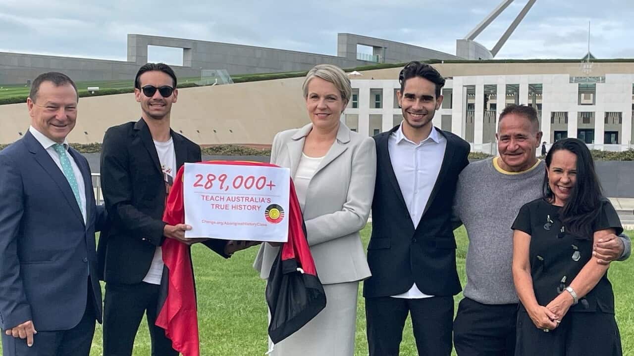 First Nations artist Isaiah Firebrace presents his petition to teach Aboriginal history in schools to Labor MPs outside Parliament House