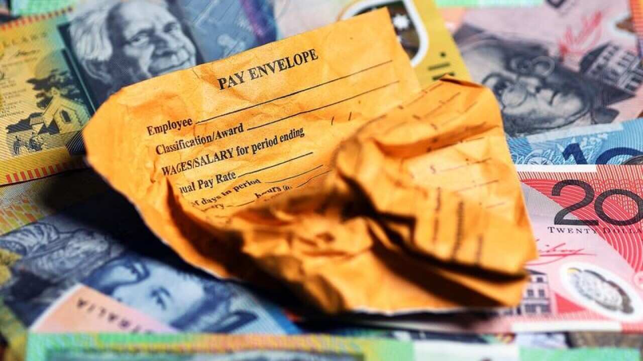 This is a file stock image of a pay envelope on top of money.