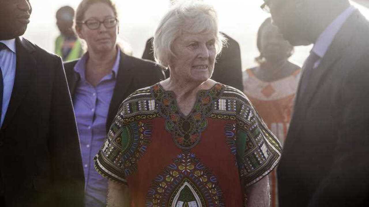 Australian Jocelyn Elliott, center, who was freed by al-Qaida captors, walks after getting off an airplane at the airport in Ouagadougou, Burkina Faso.