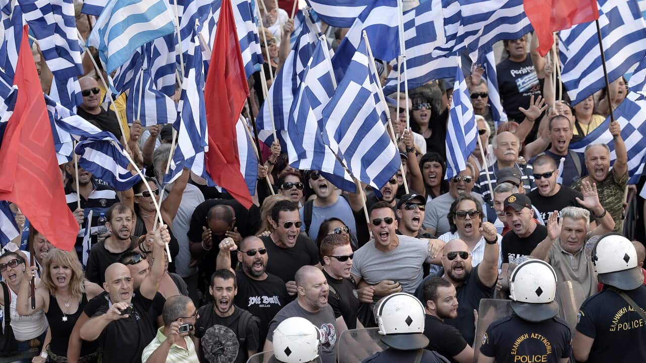 Supporters of the far right Golden Dawn party wave flags and shout slogans outside the Athens Appeals Court (File: Getty)