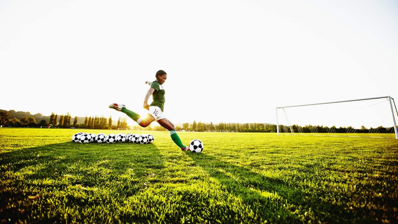 Female soccer player practicing penalty kicks