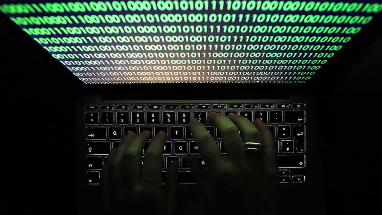 A computer monitor displays binary code