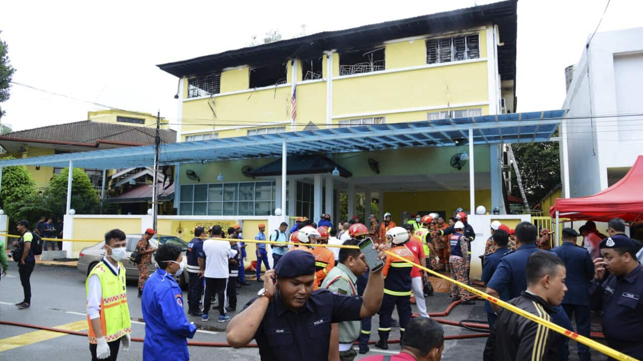 Malaysian police truck waits outside an Islamic religious school following a fire on the outskirts of Kuala Lumpur Thursday