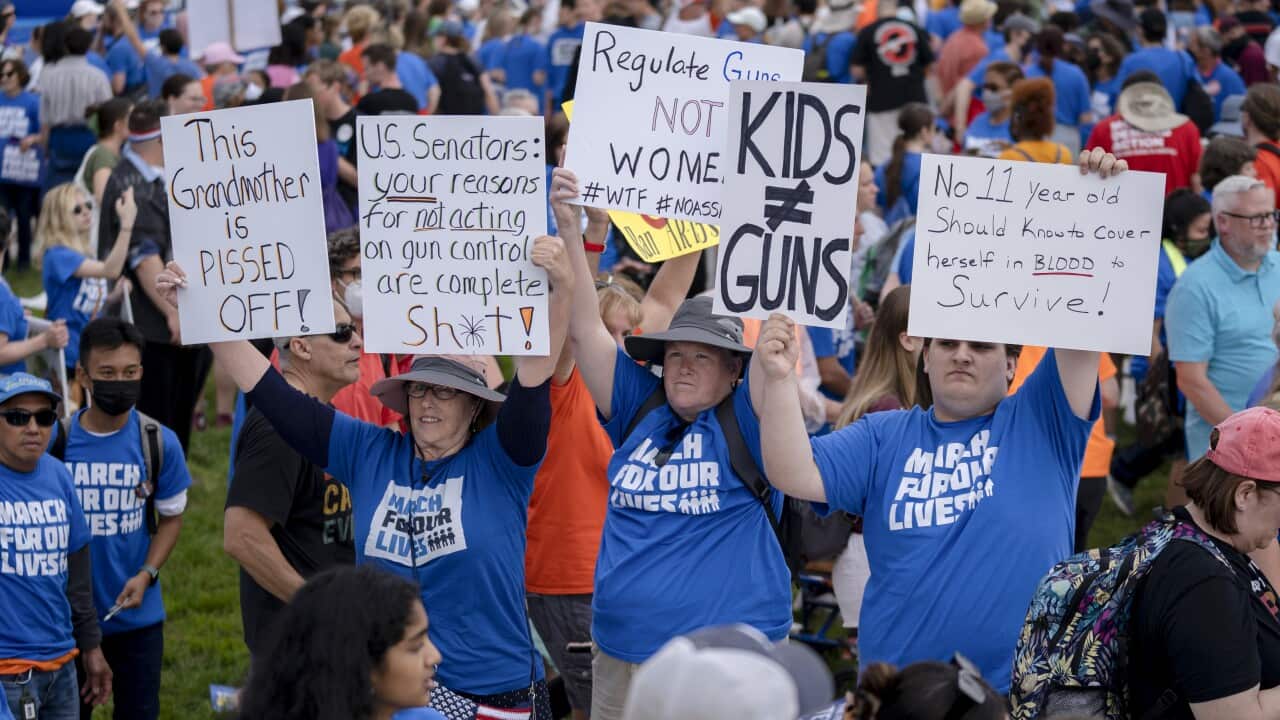 Women holding up signs at a rally