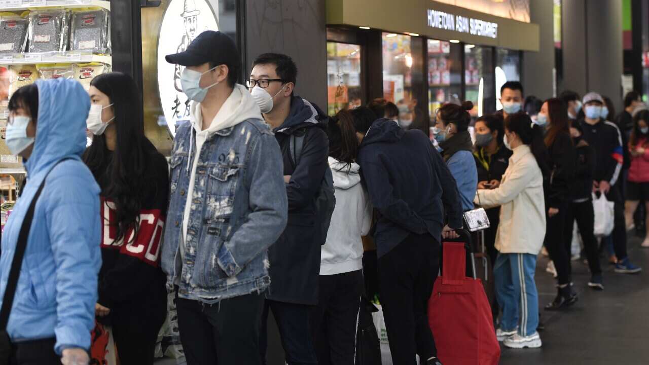People line up to enter a supermarket hours before a citywide curfew is introduced in Melbourne