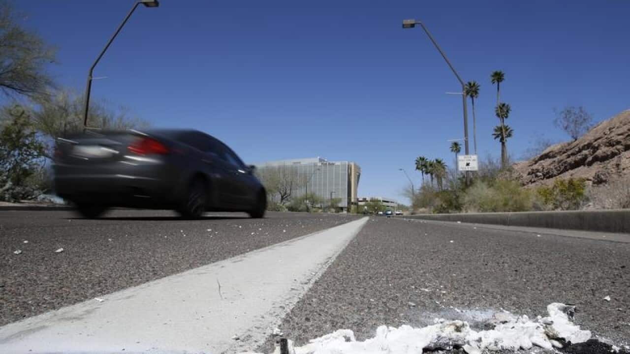 A car drives past the scene of a fatal accident in Tempe, Arizona