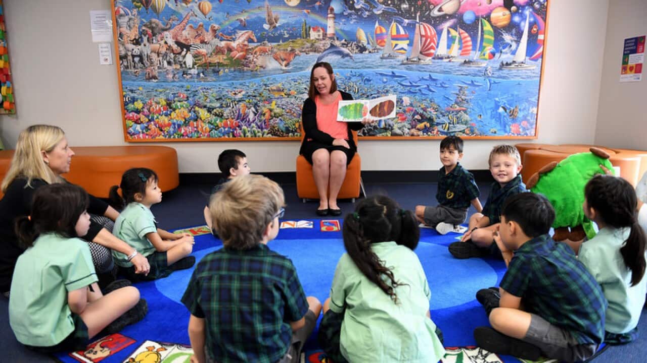 A teacher reads a story to young students at The Glenleighden School in Brisbane