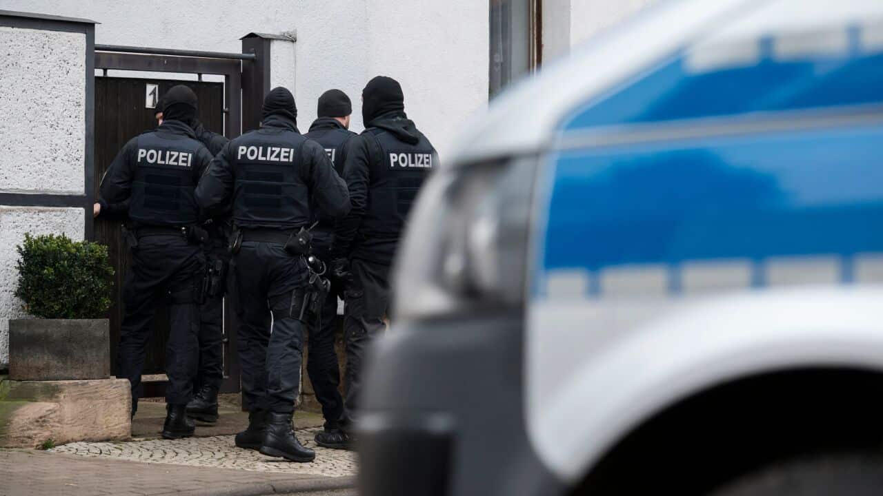 German policemen raid a home in connection with the ban of the neo-Nazi group Combat 18.