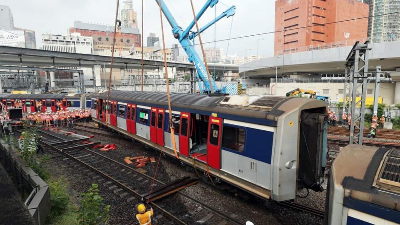 Rail engineers try to lift a carriage back on track near Hung Hom as part of the effort to get services up and running again for Wednesday morning.