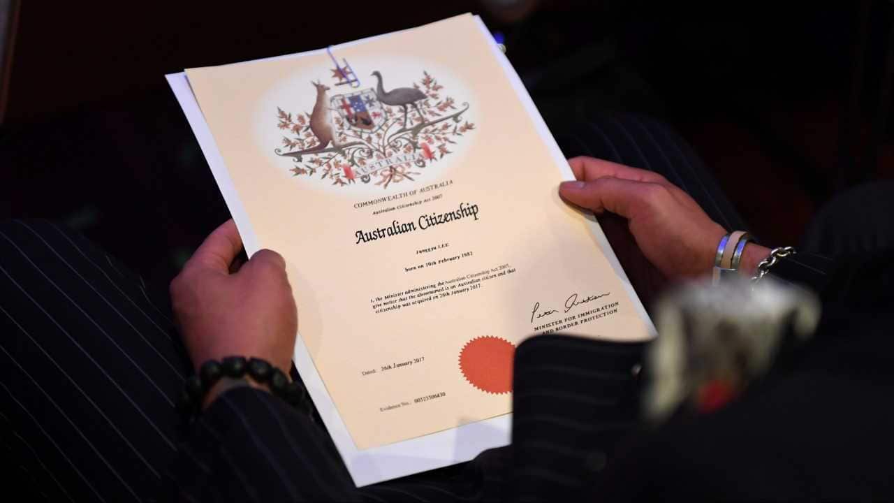An Australian citizenship recipient holds his certificate during a citizenship ceremony on Australia Day in Brisbane, Thursday, Jan. 26, 2017