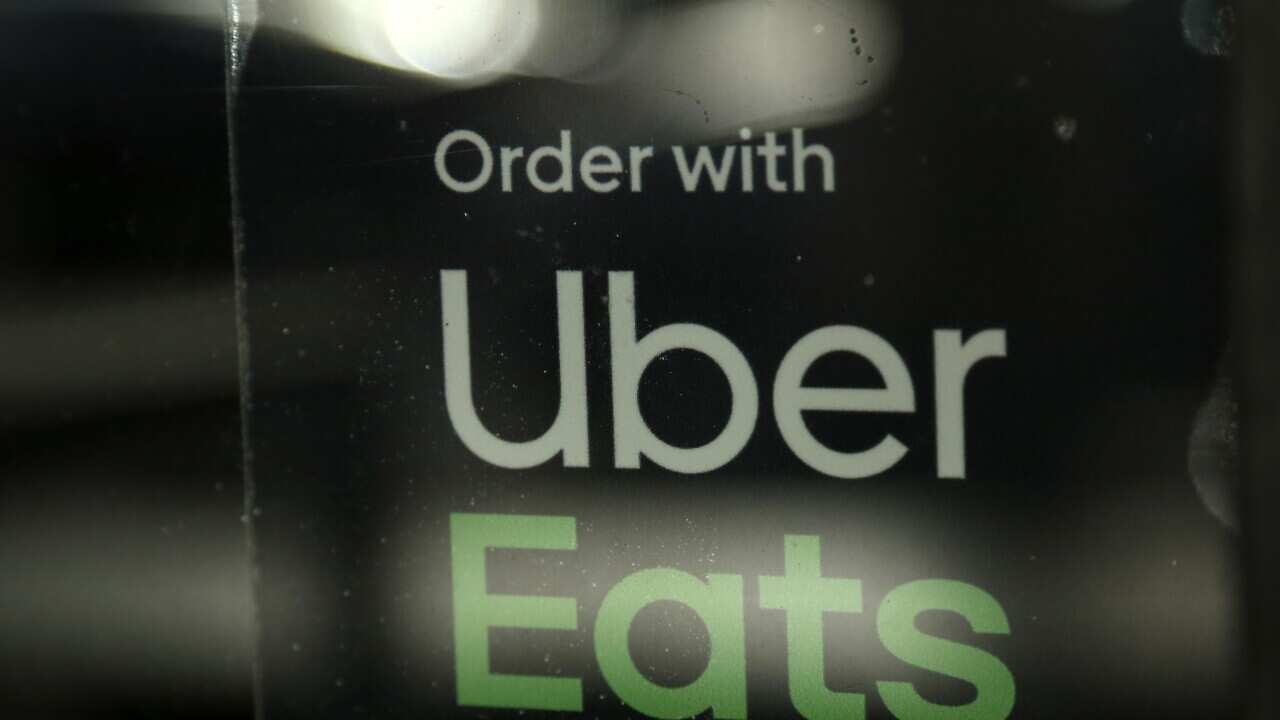 In this Wednesday, Nov. 6, 2019 photo, a restaurant advertises Uber Eats in the Coconut Grove neighborhood in Miami. (AP Photo/Lynne Sladky)