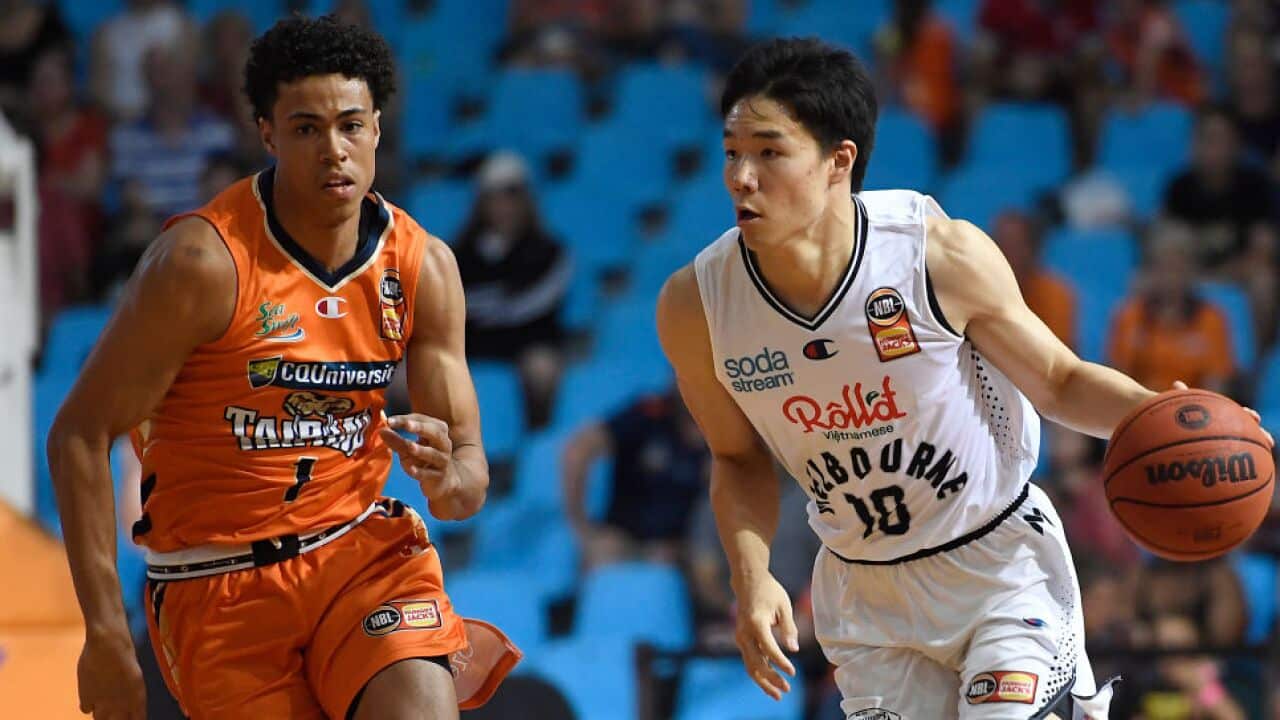 Yudai Baba (R) of Melbourne United dribbles the ball past Mojave King of the Taipans