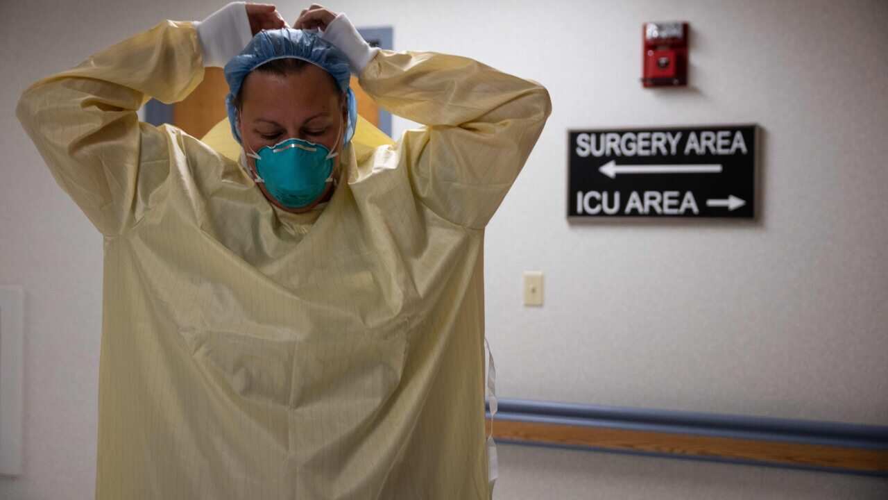 A healthcare professional suits up with PPE to enter a COVID-19 patient's room in the ICU at Van Wert County Hospital in Ohio on 20 November, 2020.
