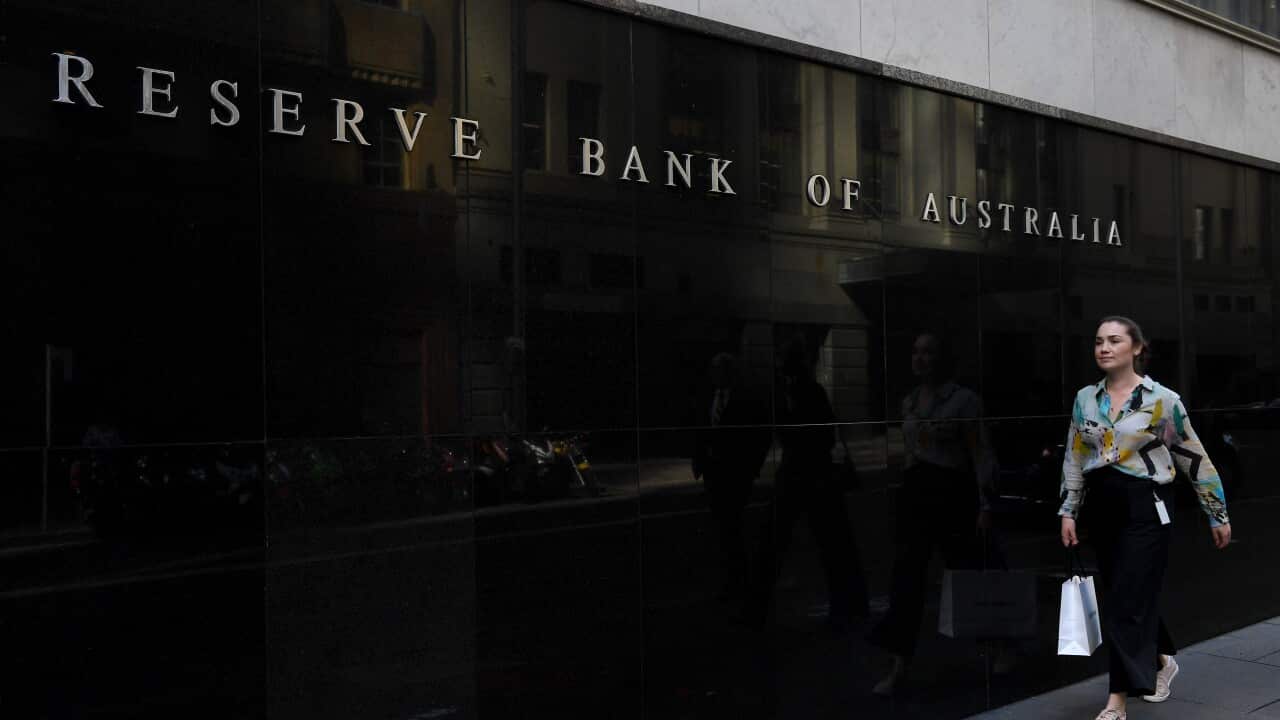 A woman walking past the Reserve Bank of Australia building.