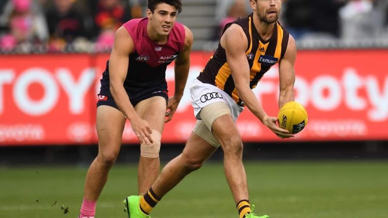 Luke Hodge gives a handball.