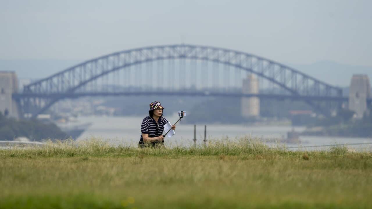 A tourist takes a selfie with the Sydney Harbour Bridge as a backdrop in Sydney.